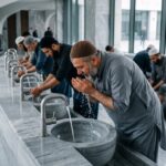 Grand ablution (ghusl) : purification rituelle islamique avec eau coulant sur les mains